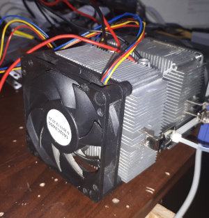 A photo of two AMD coolers attached to two peltier coolers, surrounding an aluminium water block